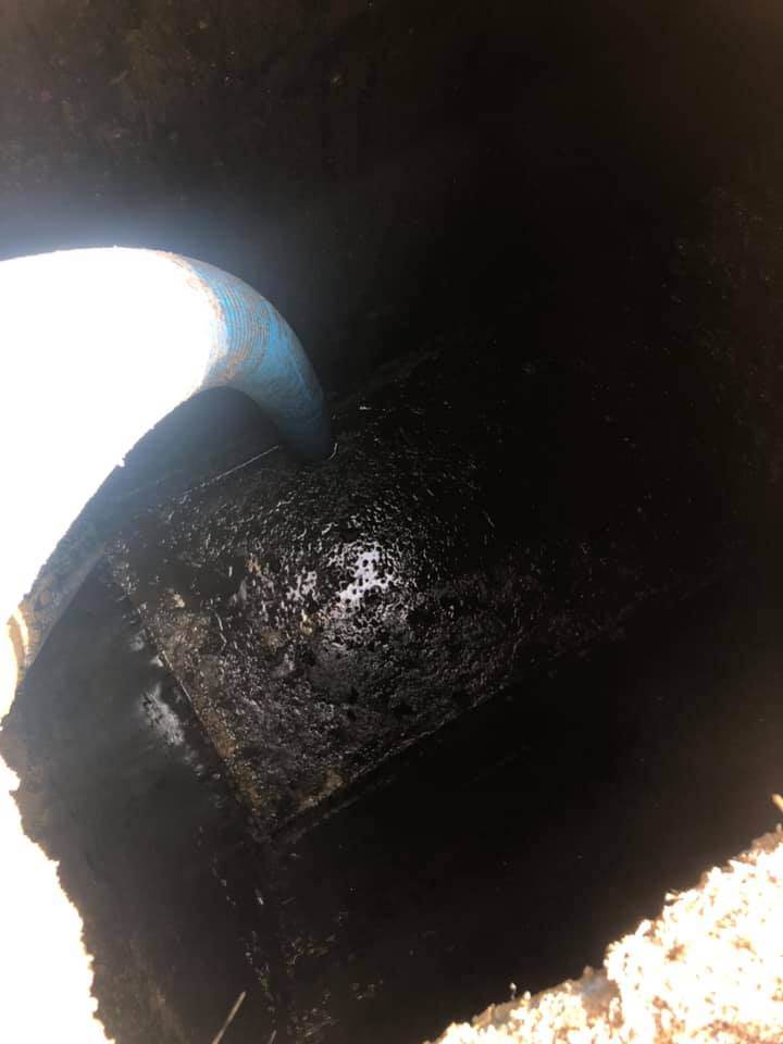 Victor Plumbing is using a blue hose to clean a septic drain.