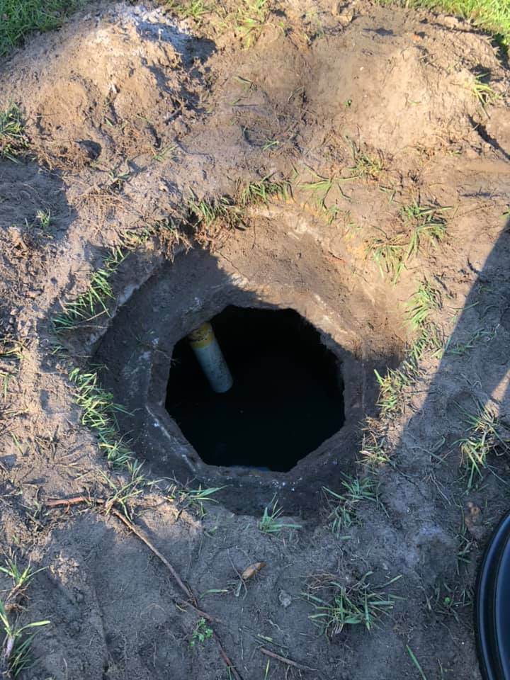 A hole in the ground with a pipe in it, connected to Victor Plumbing's septic system.