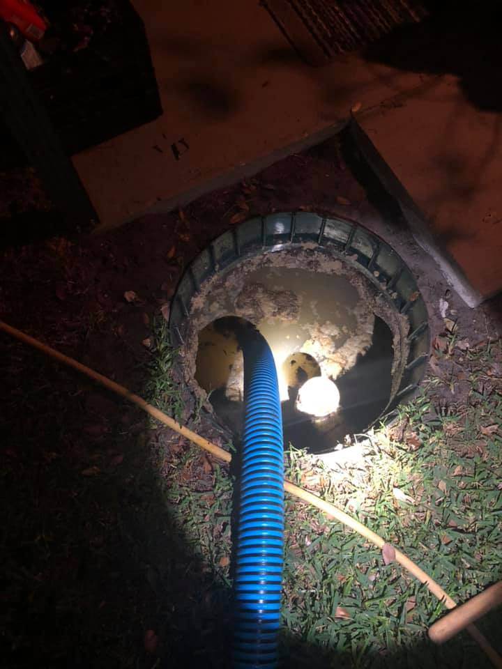 A clogged drain with a blue hose attached to it, requiring the expertise of Victor Plumbing for proper septic system maintenance.