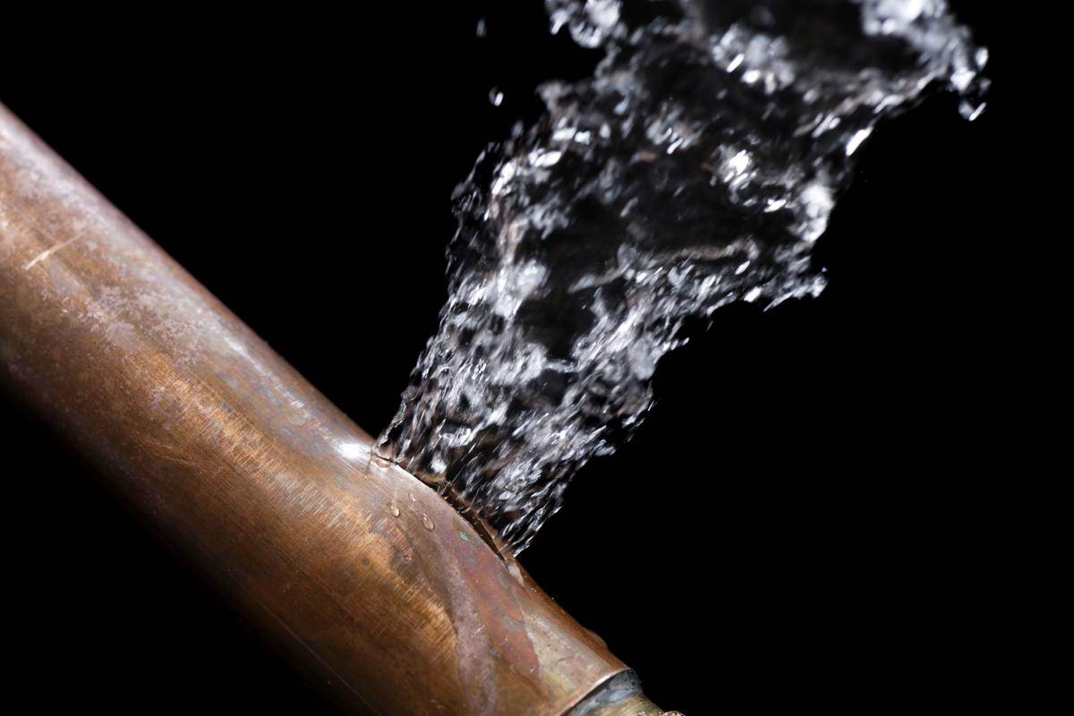 Water coming out of a pipe from Victor Plumbing on a black background.