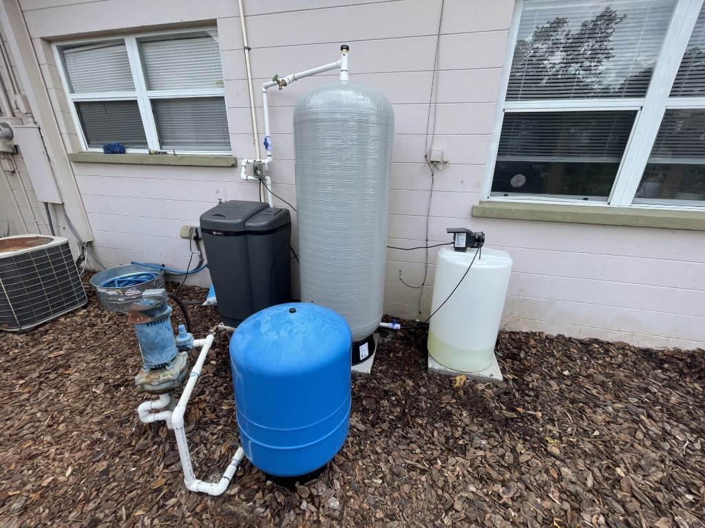 A Victor Plumbing water filtration system in front of a house.