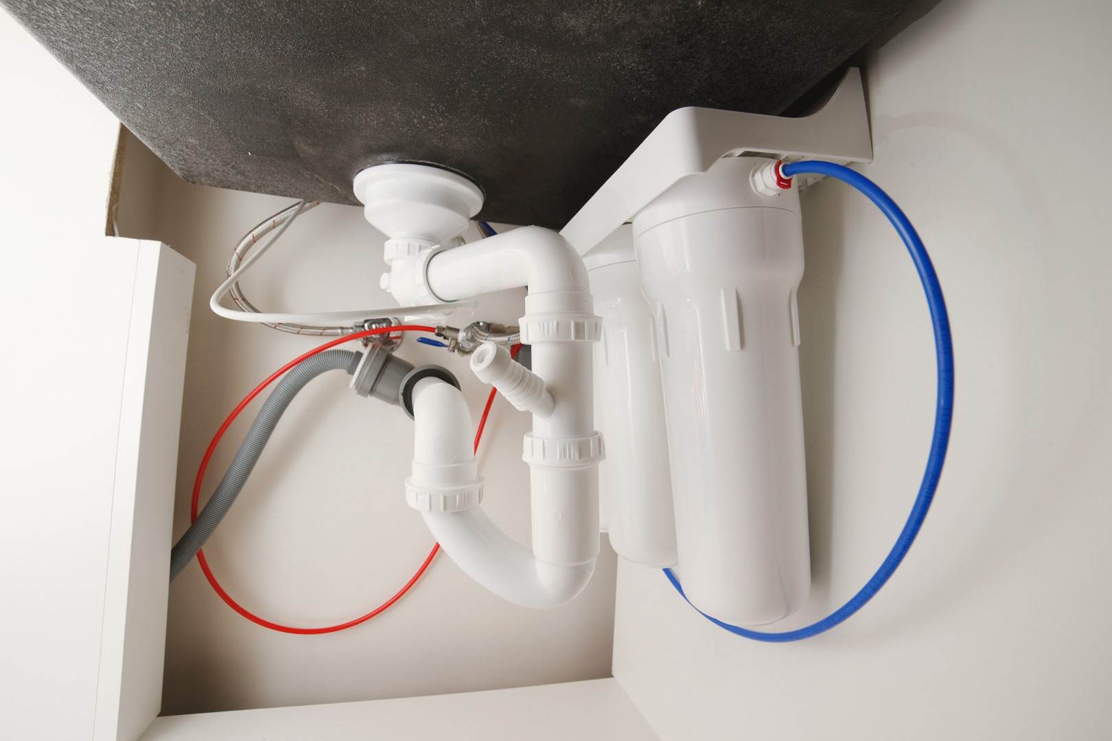 A kitchen sink with a water hose attached to it, designed for efficient plumbing and compatible with Victor Plumbing. It is also equipped for easy connection to a septic system.