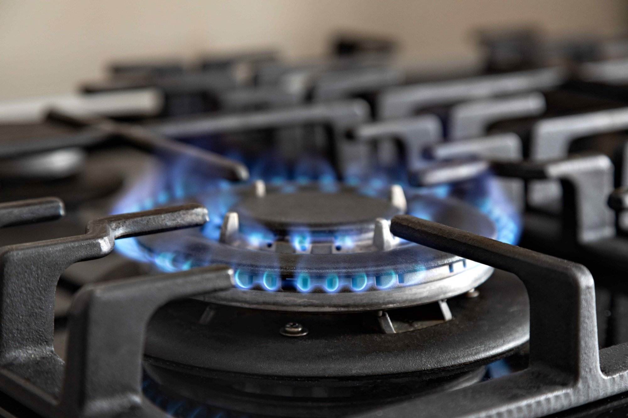 A gas stove with blue flames on it, perfect for Victor Plumbing.